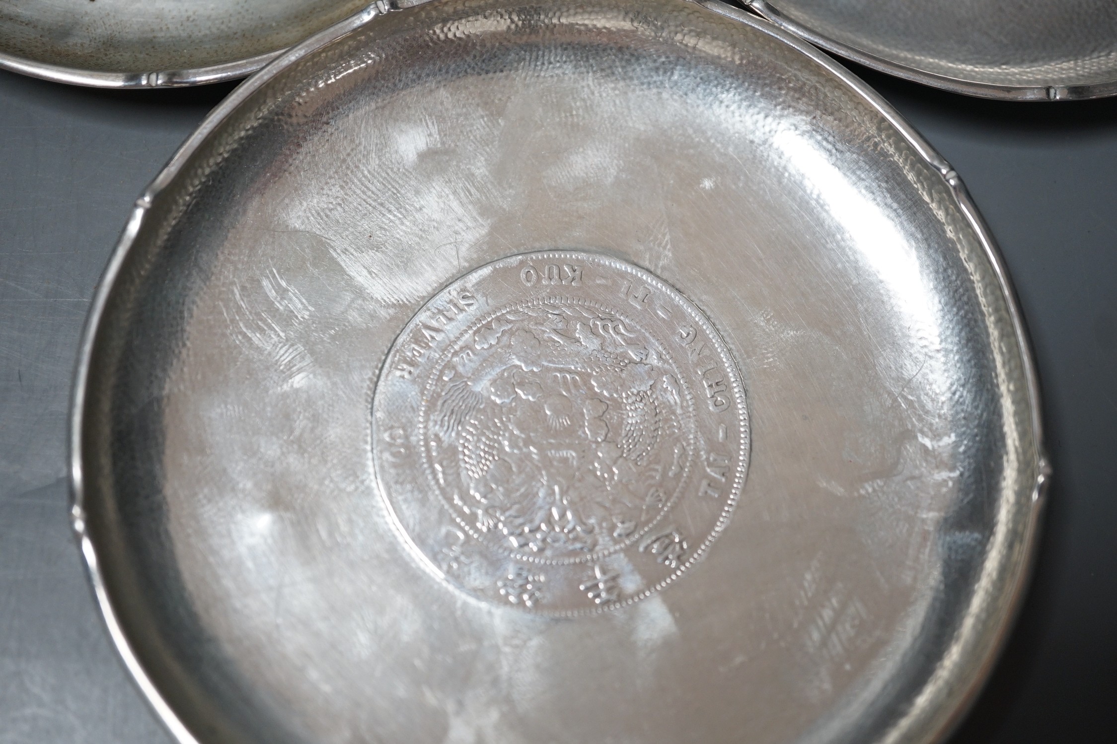 Three Chinese white metal dishes, each inset with coin, maker HC, 94mm, 196 grams gross.